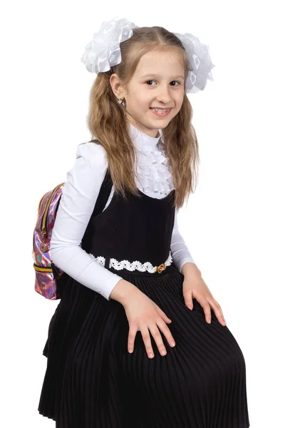 Kleine süße Schulmädchen posiert auf einem weißen Hintergrund. — Stockfoto