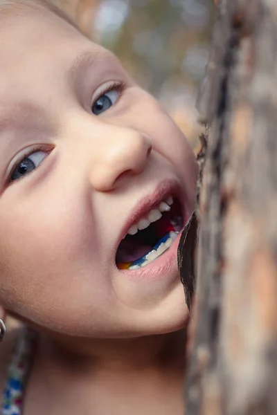 Una niña pequeña con un diente de bebé tambaleante en la boca está tratando de —  Fotos de Stock
