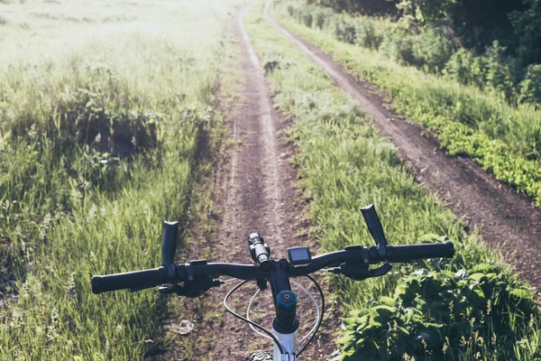 Fiets op een landweg. Uitzicht vanaf de zijkant van de fietser. — Stockfoto