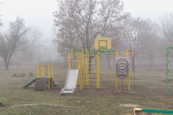 霧の秋の朝の子供の遊び場を空に — ストック写真