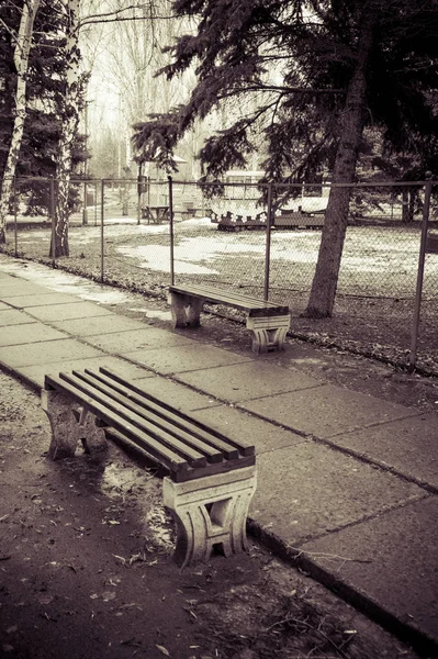 Скамейка в старом заброшенном парке. Ранняя весна и наземный ков — стоковое фото