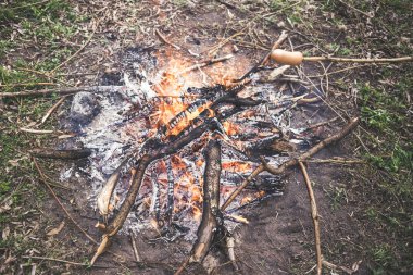 Ormanda bir yangında kızarmış sosis pişirme