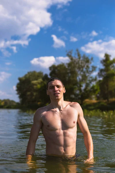 Portret van een knappe jonge man in het water. — Stockfoto