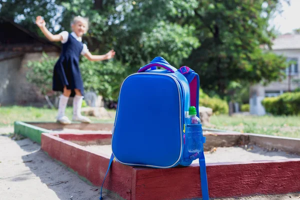 Σχολική τσάντα και μια στοιχειώδη φοιτητής σε παιδική χαρά — Φωτογραφία Αρχείου