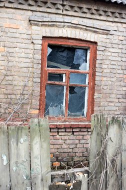 Pencereleri kırık, terk edilmiş eski bir ev.