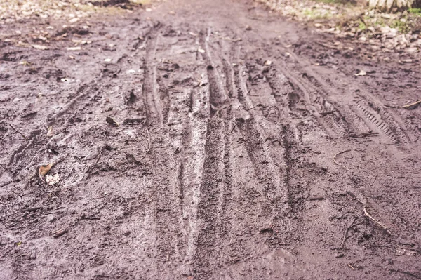 Bottes et empreintes de vélo dans la boue — Photo