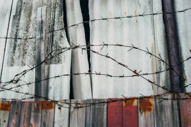 Eski boyalı çit ve paslı dikenli tel