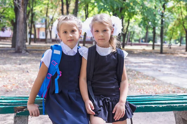 Two schoolgirls with a backpack in the park. — Stock Photo, Image