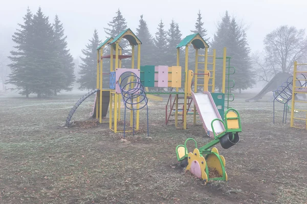 Leerer Kinderspielplatz an einem nebligen Herbstmorgen — Stockfoto