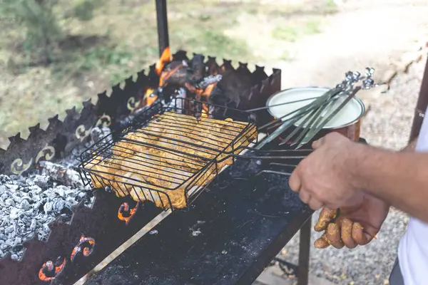El hombre fríe pollo marinado en una rejilla metálica — Foto de Stock