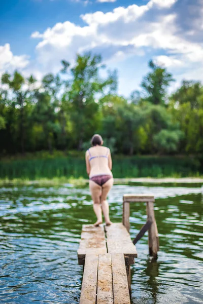 Een Mooie Vrouw Die Van Een Pier Het Water Springt — Stockfoto