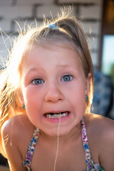 Bir bebek dişini iplik kullanarak çıkarma işlemi.