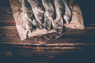 Tahta bir masada kağıt torbada kurutulmuş balık. Stüdyo fotoğrafı.