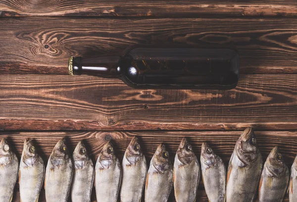 ビールと乾燥魚を木製のテーブルの上に茶色のボトル スタジオ写真 — ストック写真