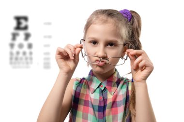 Beyaz arka planda poz veren gözlüklü tatlı bir kız. Kötü görüşlü çocuk