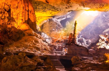 Beautiful gold sunlight shining to Sung Sot Cave or Surprise Grotto on Bo Hon Island is one of finest and widest grottoes of Ha Long Bay, situated in the center of UNESCO-declared World Heritage area clipart