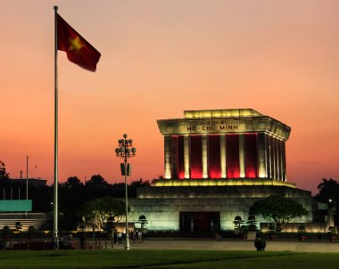 Ho Chi Minh mausoleum önünde Vietnam ulusal bayrak, Hanoi, Vietnam için koruma beyaz üniforma askerler ile güzel gün batımı görünümü.
