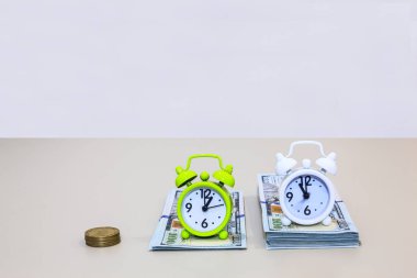 Çalar saat bize dolar para yığınları başvurmak için para ifade tam zamanı. İş ve finans kavramı.