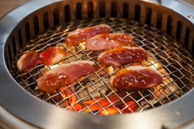 Gıda Restoran Barbekü ızgara soba arka plan kafes tavada kızartma Glowing ve yanan sıcak doğal ahşap kömür yumru kavurma ördek eti ve sebze yemek.