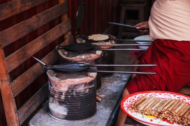 Kadın tanga Muan (Tay gevrek Hindistan cevizi gofret rulo çerez pirouline için benzer) kömür toprak soba üzerinde sıcak kalıp tavada pişirme. Geleneksel Tayland sokak gıda, tatlı, tatlı ve iştah açıcı kavramı