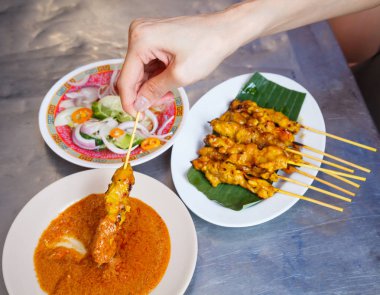 geleneksel Tay street yemek tarifi, domuz eti Satay ızgara domuz eti stick Muz Yaprak Beyaz tabak tatlı fıstık daldırma sos ve sirke ile servis içinde koyarak meze tabağı. Tayland Asya gıda seyahat