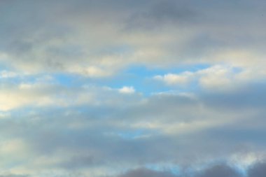 Beyaz bulutlar mavi gökyüzünde güneş ve rüzgar birlikte dans tadını çıkarıyor.