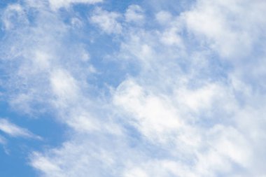 Yumuşak beyaz bulutlar mavi gökyüzü ile esen rüzgar ile harika görünüyorsun.