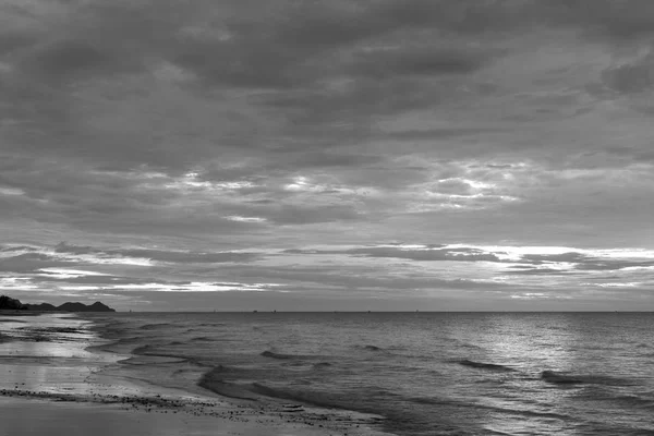 The sun began to rise from the sea in the morning backdrop black and white style.