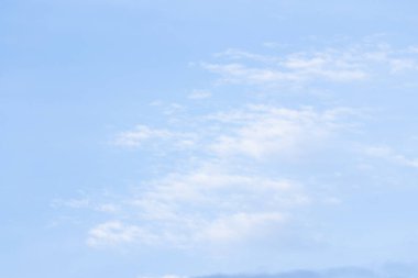 Turkuaz mavi arka plan önünde beyaz bulutlar float.