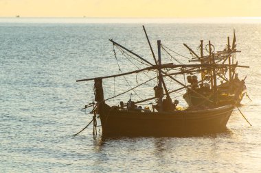 Sabah güneşiyle Denizde bir tekne.