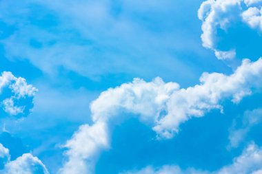  Beyaz bulutlar mavi gökyüzünde güneş ışığı ile.