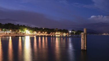 Moniga del Garda gece ışık yansıması su ile