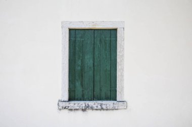 Beyaz bir duvar üzerinde kapalı bir yeşil ahşap pencere fotoğrafı