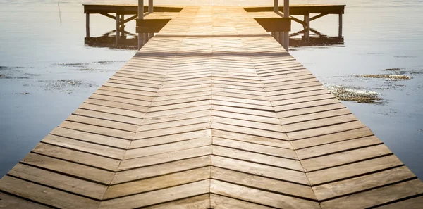 日の出コピー スペースと静かな水の上の木製のドックの背景 — ストック写真