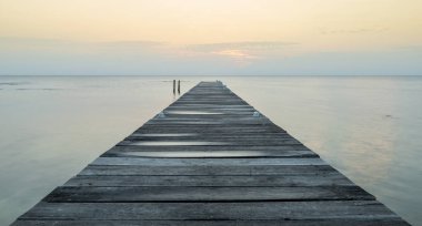Sessiz okyanusa doğru uzanan bir ahşap iskelesi şafak