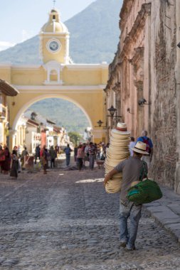 Antigua, Guatemala - 24 Şubat 2018: tanımlanamayan adamın şapka satan turistik şehir Antigua, Guatemala ünlü Santa Catalina kemerin altında girer.