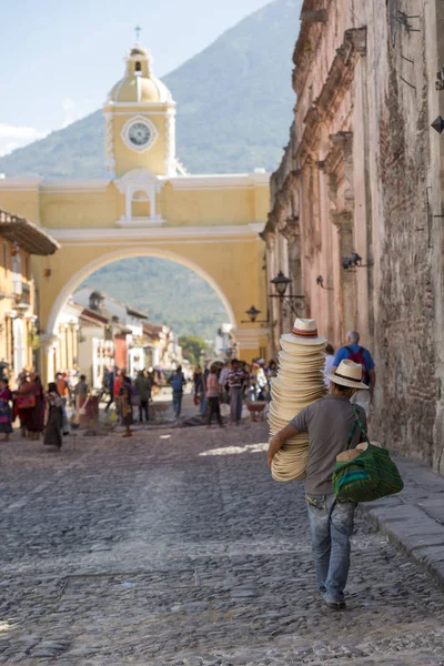Antigua, Guatemala - 24 Şubat 2018: tanımlanamayan adamın şapka satan turistik şehir Antigua, Guatemala ünlü Santa Catalina kemerin altında girer.