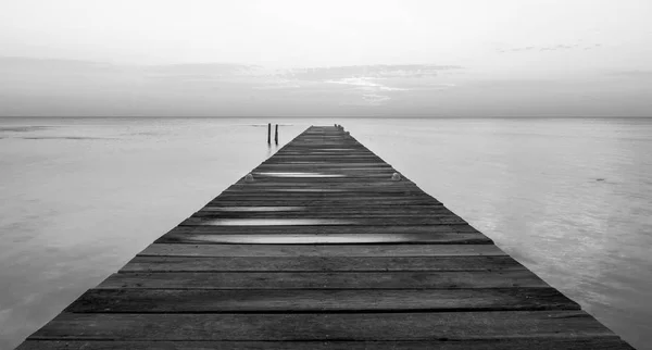 Trä jetty vid gryningen svart och vitt — Stockfoto