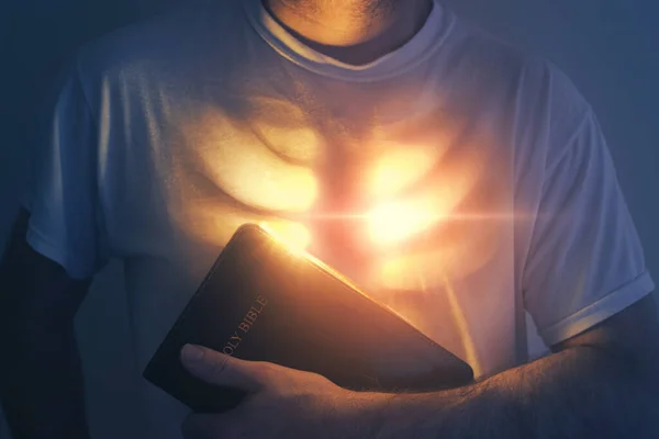 彼の心は明るい光で輝いているので 男は聖書を保持しています — ストック写真