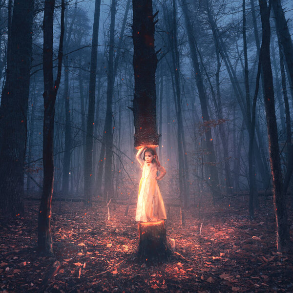 A surreal image of a little girl lifting up a large tree