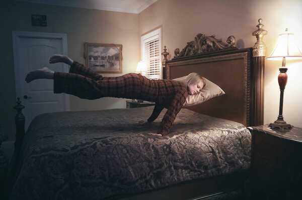 Женщина кладёт голову на подушку и плавает над кроватью..