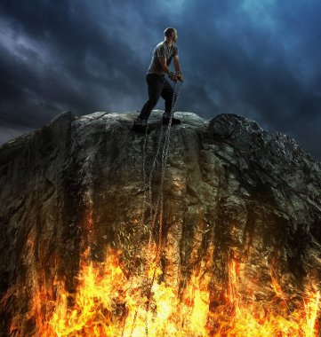 Aşağıdaki ateşe giden zincirlenmiş bir adam.