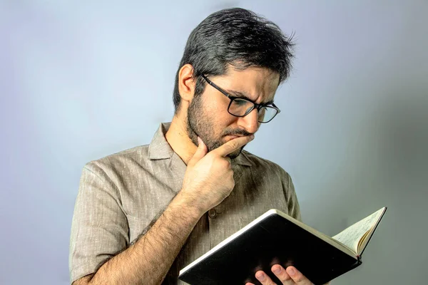 A young lecturer professor holding a book and thinking