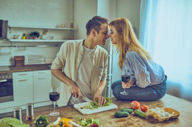 Sağlıklı yemek yemek ve evde mutfak kırmızı şarap içme mutlu çift
