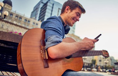 Gitar çalan genç bir adam. Havalı hippi çocuk müzikten hoşlanır.
