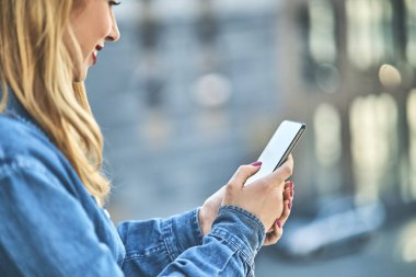 Kot pantolon giyen genç bir kız dışarıda boş zaman geçirir. Akıllı telefonla konuşur, güler yüzlü, yakın plan çekimler yapar.