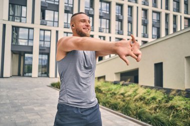  Pozitif adam güneşli bir günde yüksek bir binanın yakınında spor yapmaya gider..