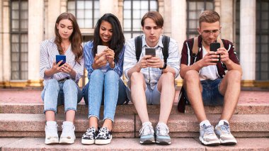 Lise öğrencileri oynuyorlar, sohbet ediyorlar ve telefonlara sarılıyorlar..