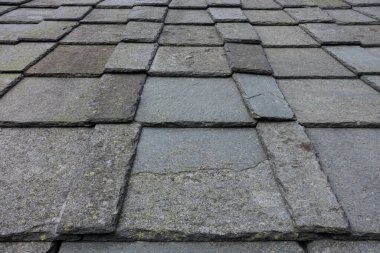 Mavi gökyüzü ve bulutlu eski çatı kiremitleri.