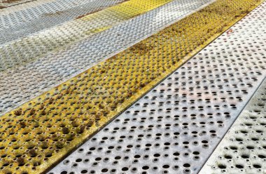Kare deliklerin delindiği metal zemin. Kum metalinin gri ve renkli çelik dokusu